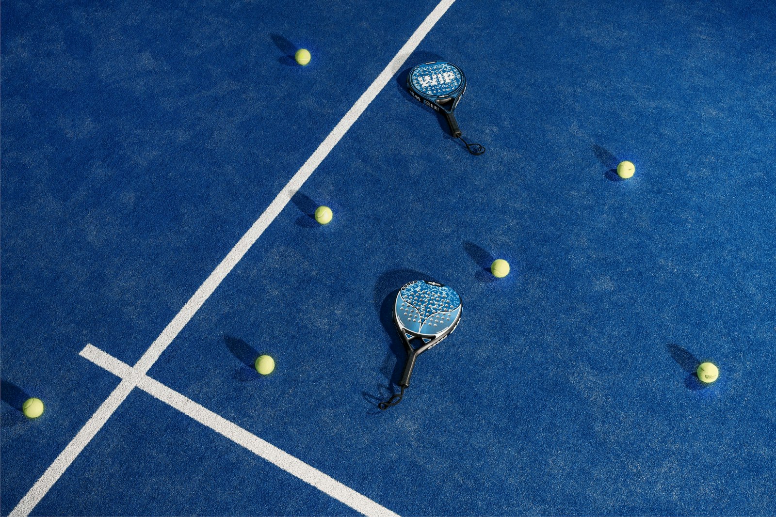 Padel players in a rally on an indoor court
